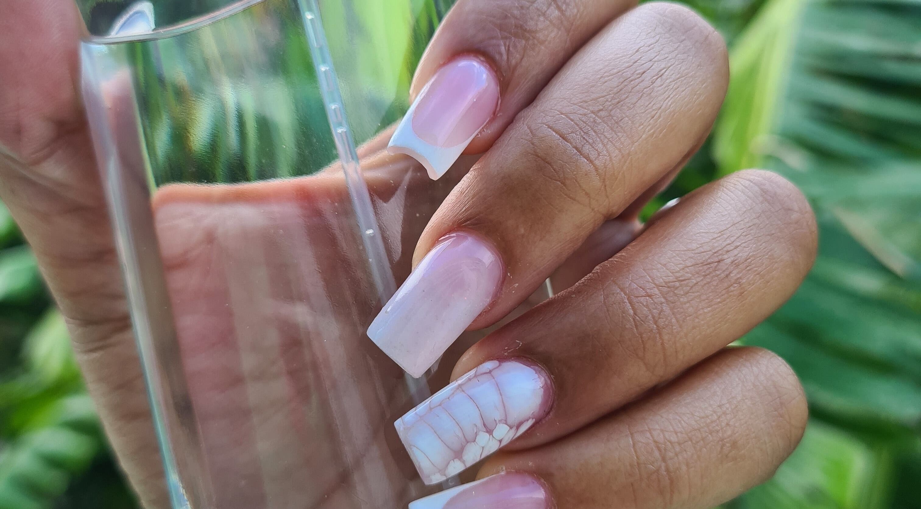 Beautiful pink and white French nails at The Nail Spot, Roseau, DM, showcasing exquisite manicure artistry.