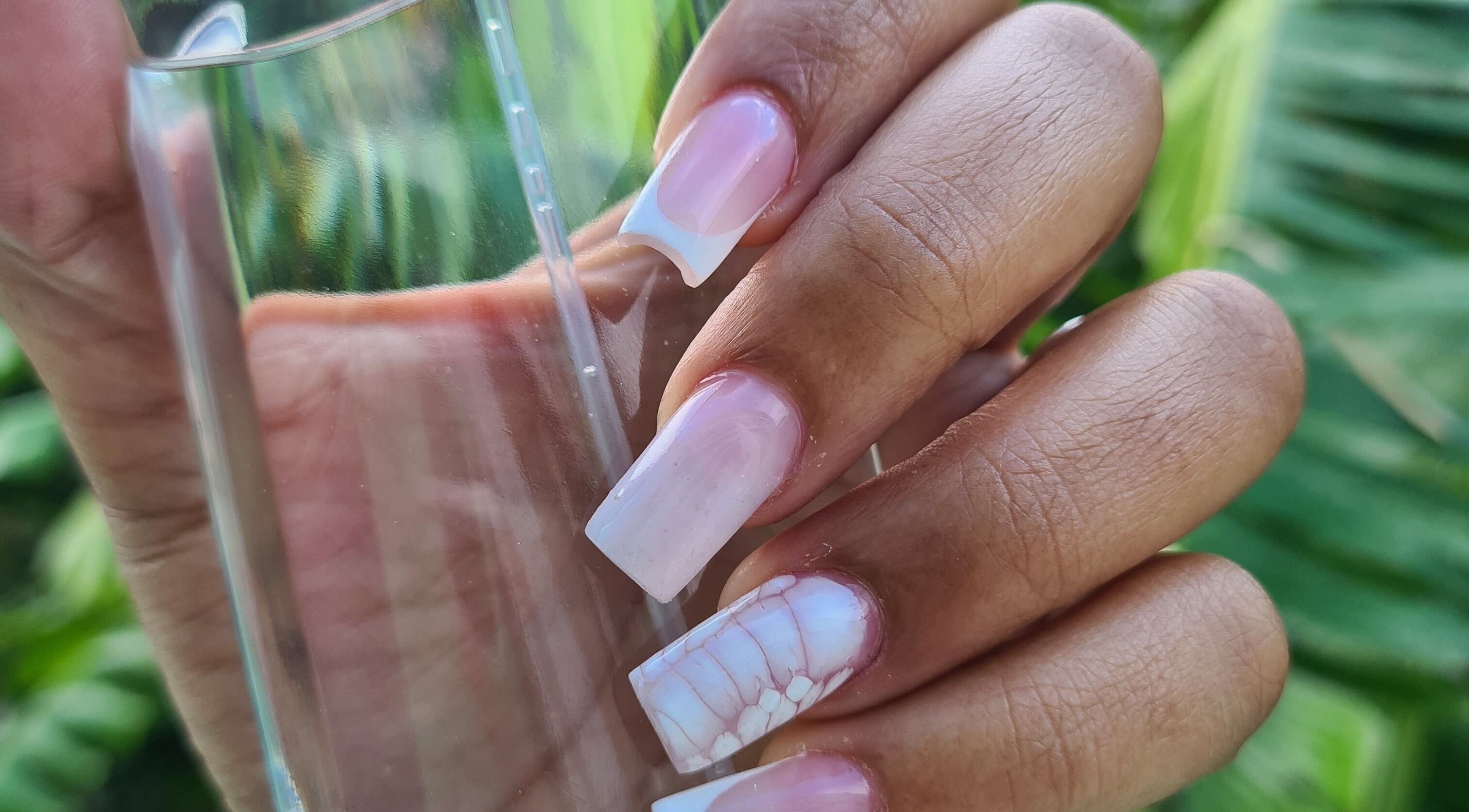 Beautiful pink and white French nails at The Nail Spot, Roseau, DM, showcasing exquisite manicure artistry.