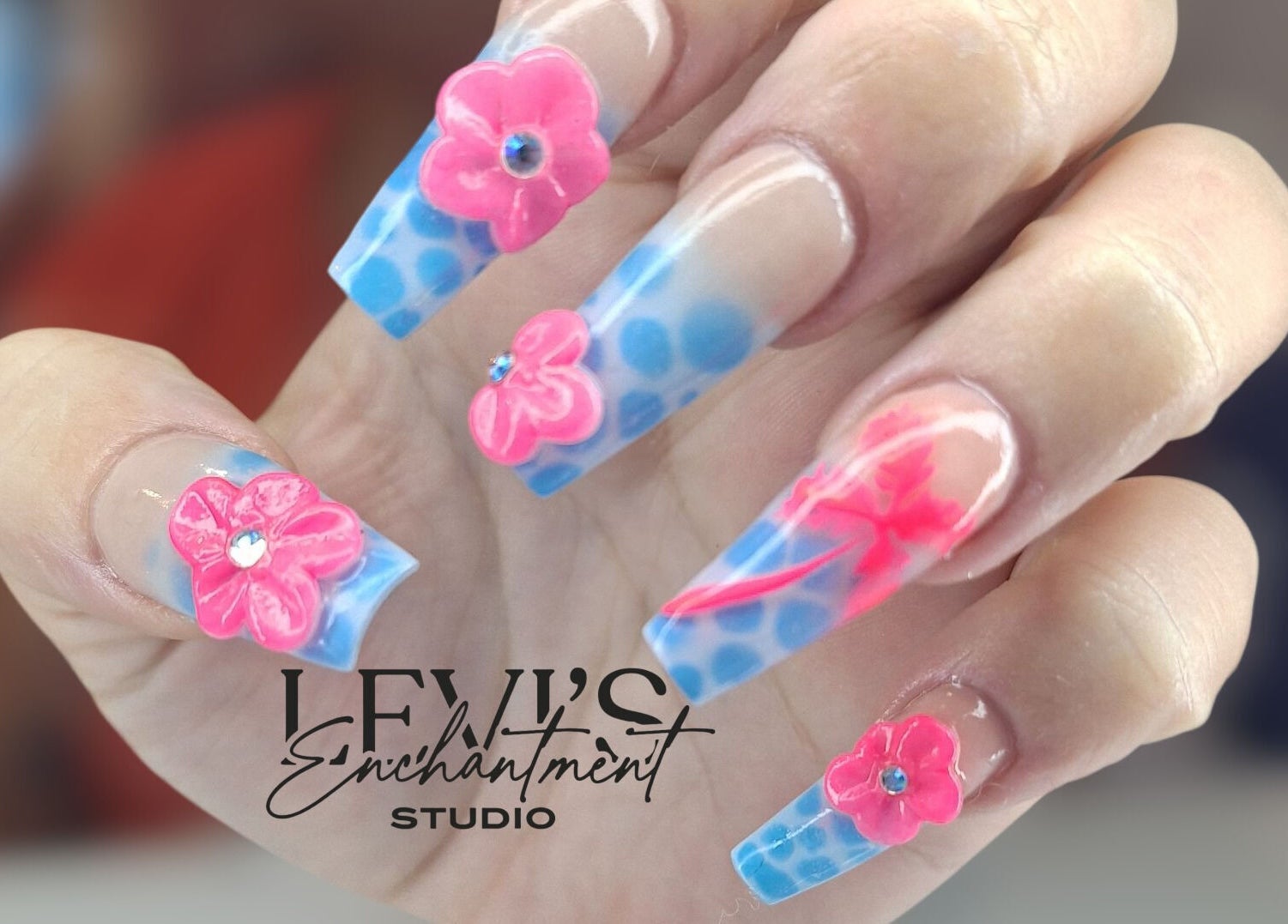 Detailed pink and blue floral nail art at Levi's Enchantment Studio, Torquay, England, GB.