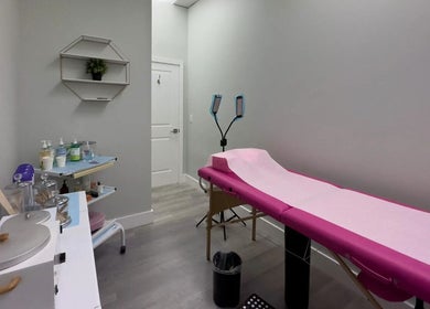 Treatment room at The Lotus Chair, LLC in Boca Raton, Florida, US with a massage table and skincare products.