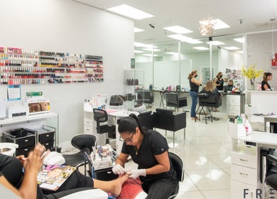 Busy salon interior at The Lotus Chair, LLC in Boca Raton, Florida, US, featuring manicure and hair styling.