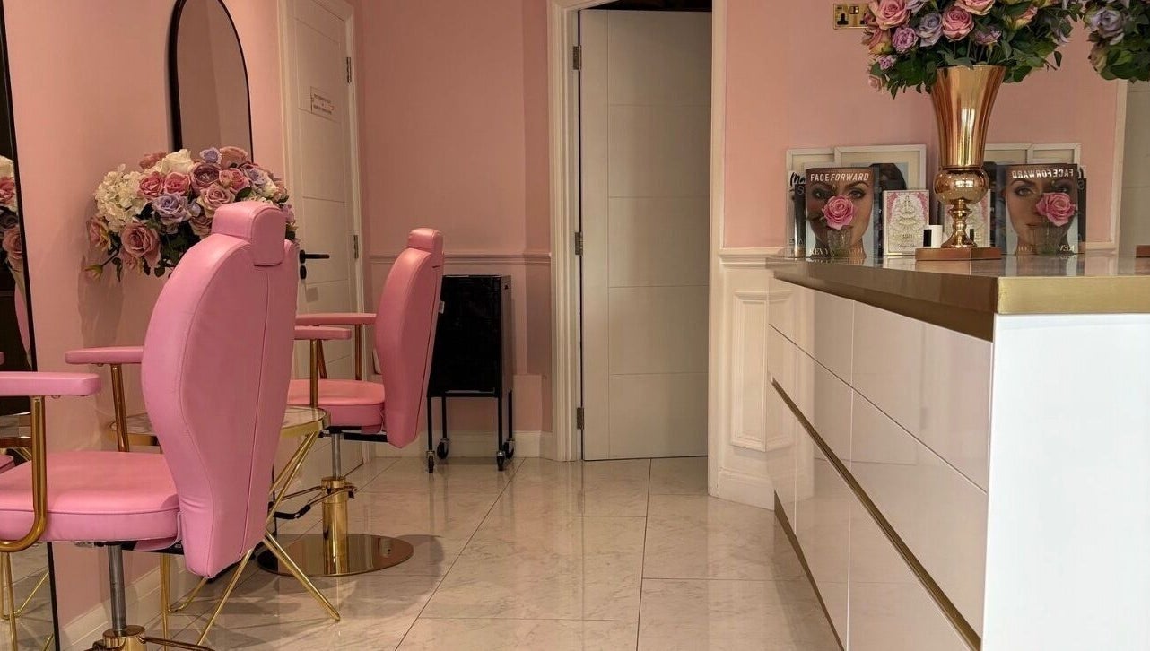 Elegant pink interior of LSR Lounge in Windlesham, England, GB featuring plush chairs and floral decor.