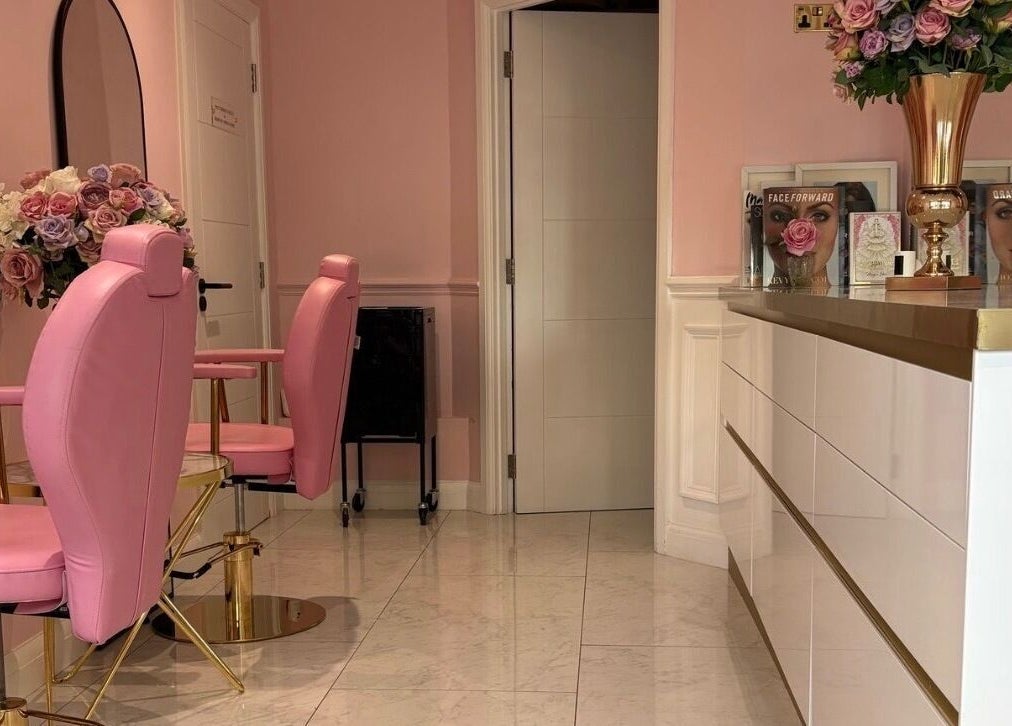 Elegant pink interior of LSR Lounge in Windlesham, England, GB featuring plush chairs and floral decor.