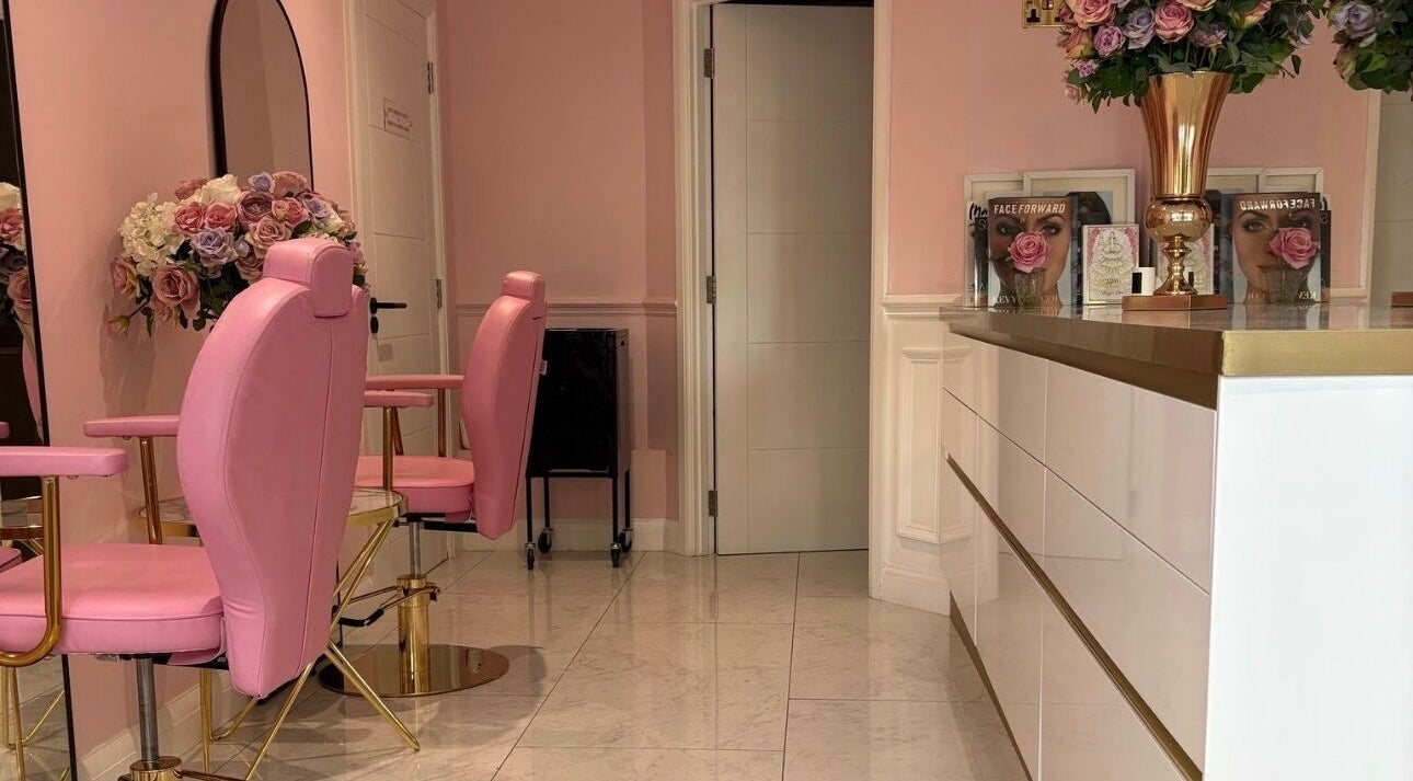 Elegant pink interior of LSR Lounge in Windlesham, England, GB featuring plush chairs and floral decor.