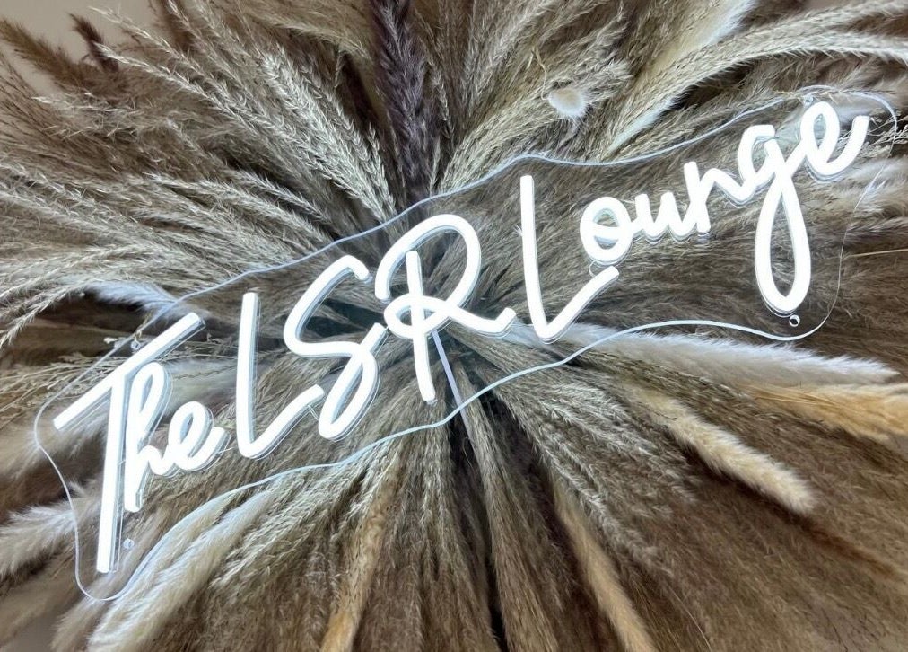 Neon sign reading 'The LSR Lounge' with pampas grass at LSR Lounge, Windlesham, England, GB.