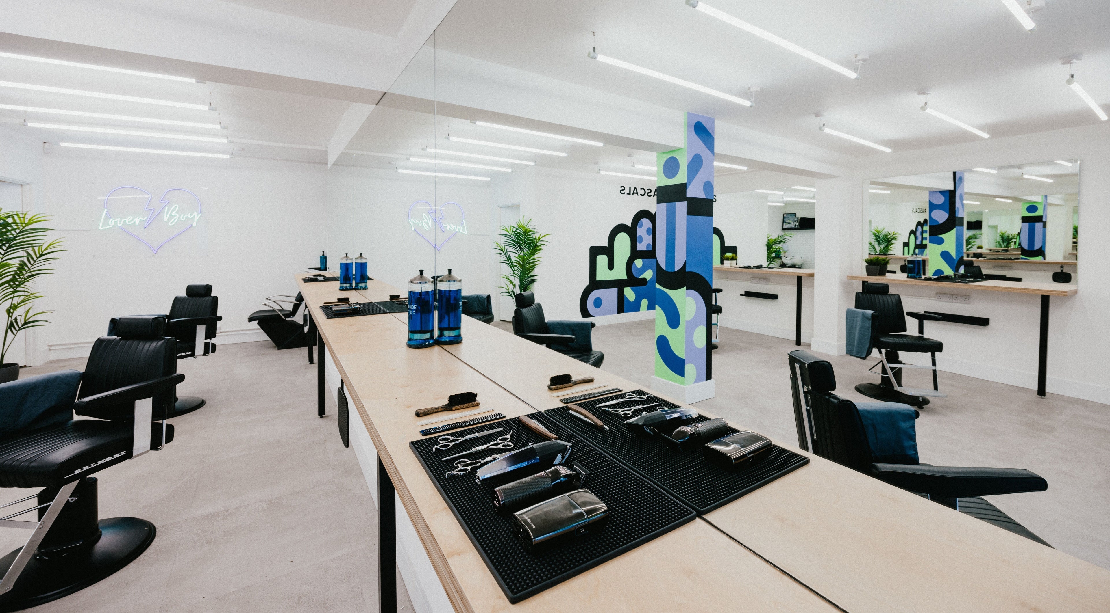 Modern interior of Rascals - Low Friar Street, Newcastle upon Tyne, England, GB. Stylish black salon chairs and mirrors.