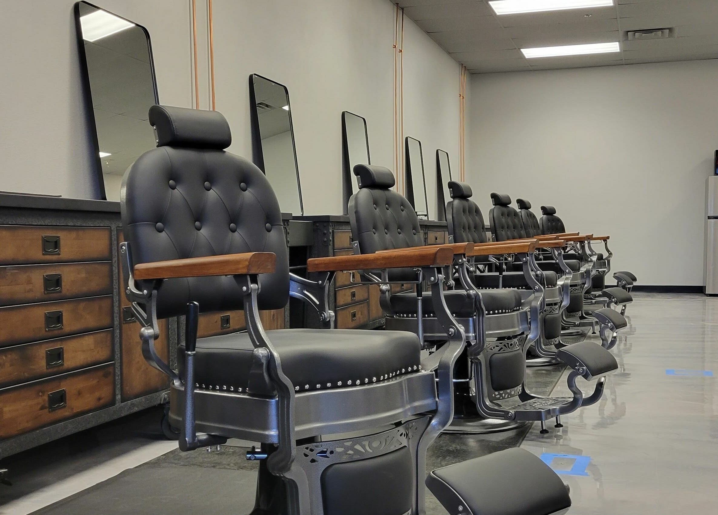 Elegant barber chairs at Executive Men's Grooming Mesa in Mesa, Arizona, US, showcasing sleek design.