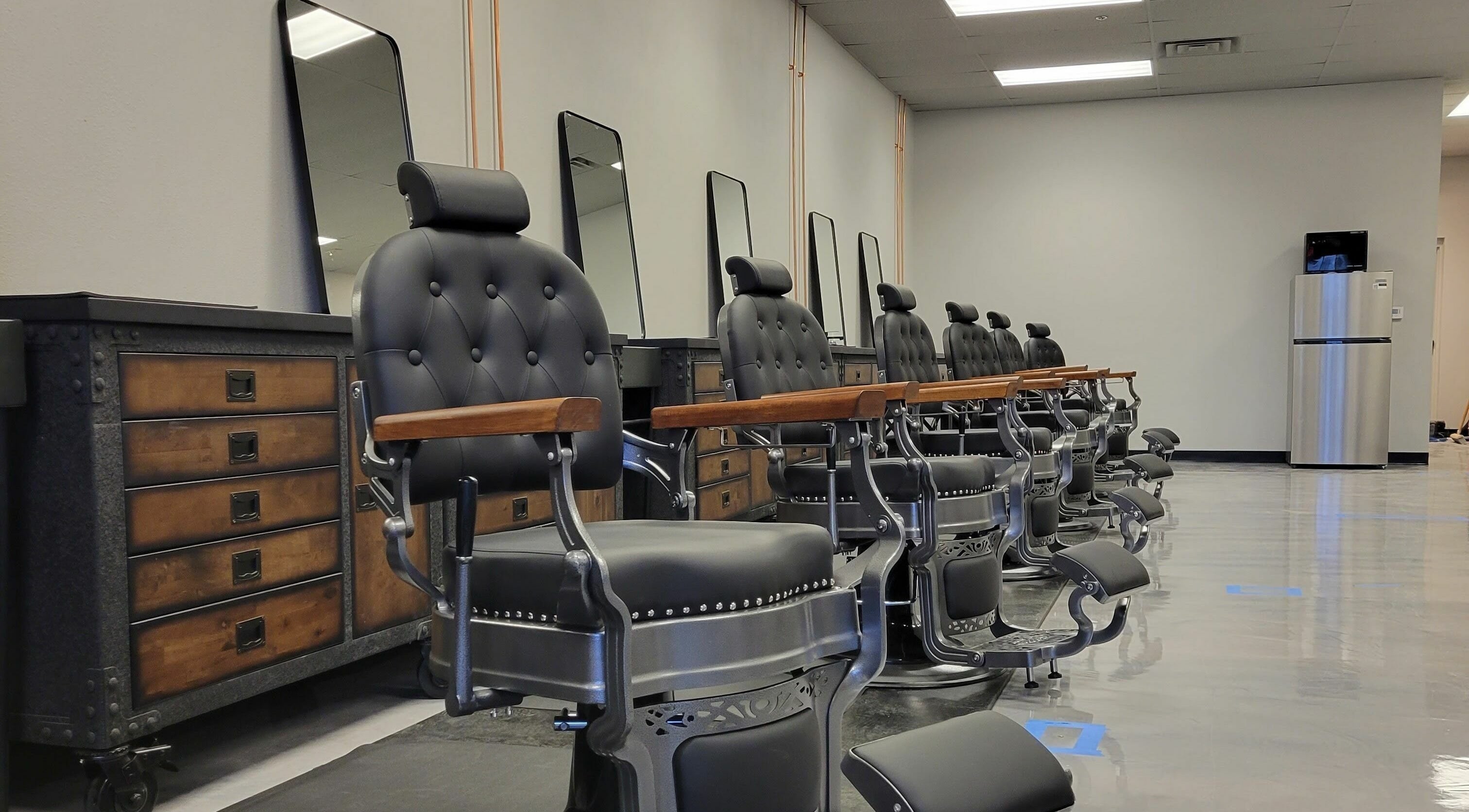 Elegant barber chairs at Executive Men's Grooming Mesa in Mesa, Arizona, US, showcasing sleek design.