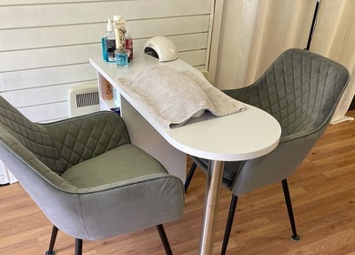 A cozy nail salon setup at The Soul Sanctuary in Little Brickhill, England, GB with plush chairs and manicure table.