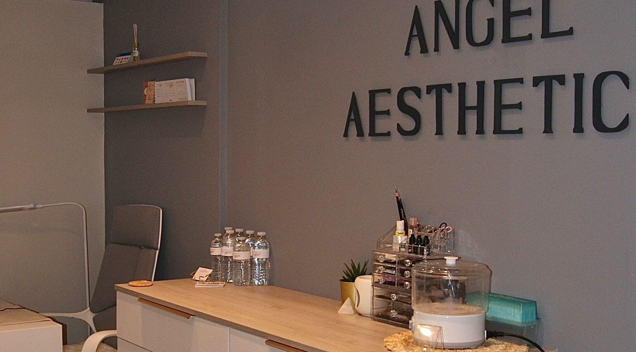 Interior of Angel Aesthetics Tattoo and Beauty, Orpington, England, GB with a modern grey wall and sleek furniture.