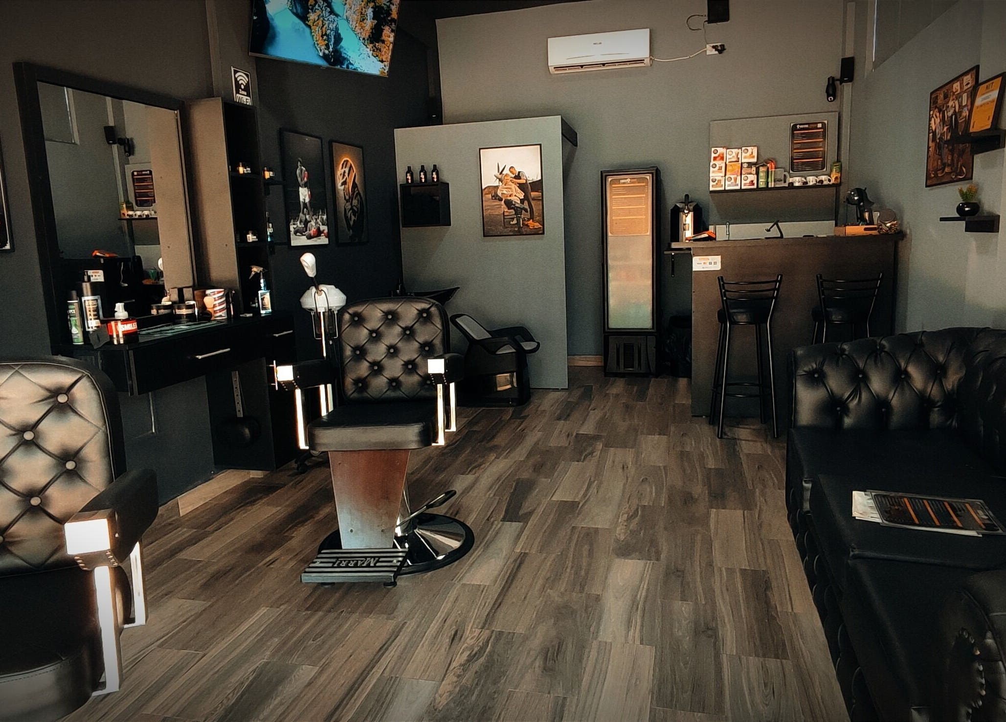 Interior moderno de Invictus Barbers & Coffee en Santa Cruz de la Sierra, BO, con sillas de cuero y decoración elegante.