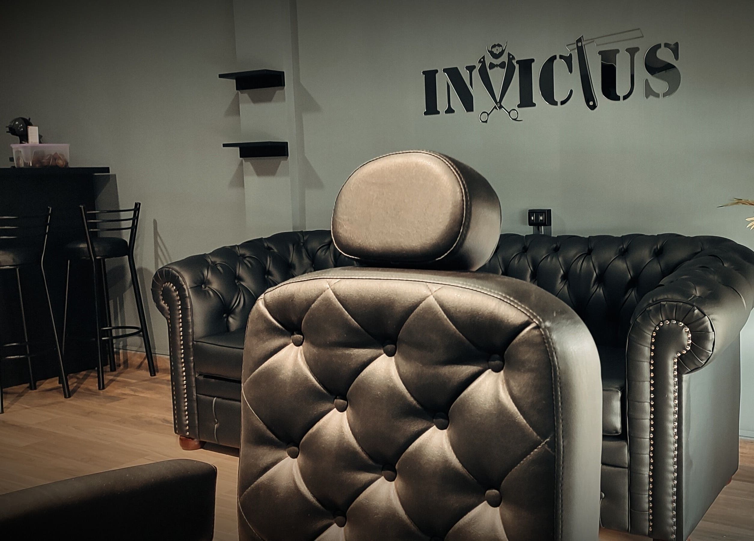 Interior de Invictus Barbers & Coffee en Santa Cruz de la Sierra, BO con sofás y sillas elegantes.