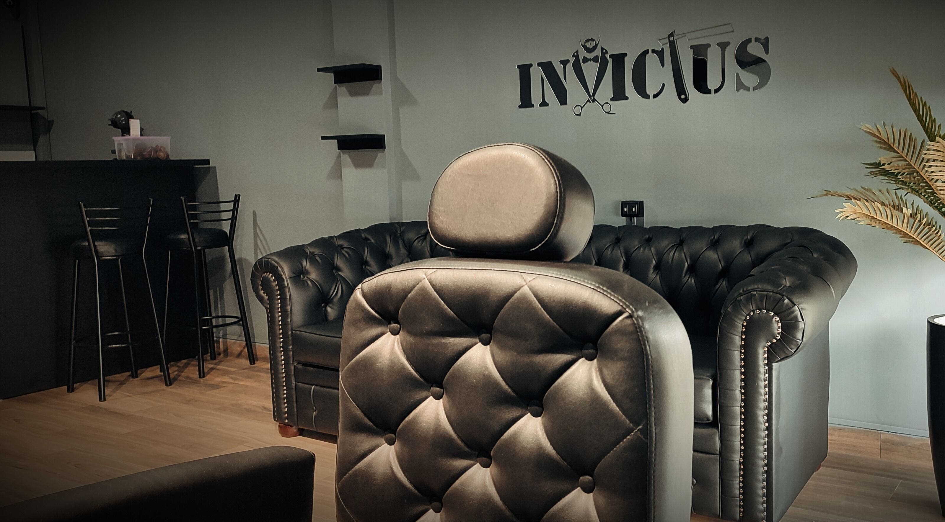 Interior de Invictus Barbers & Coffee en Santa Cruz de la Sierra, BO con sofás y sillas elegantes.