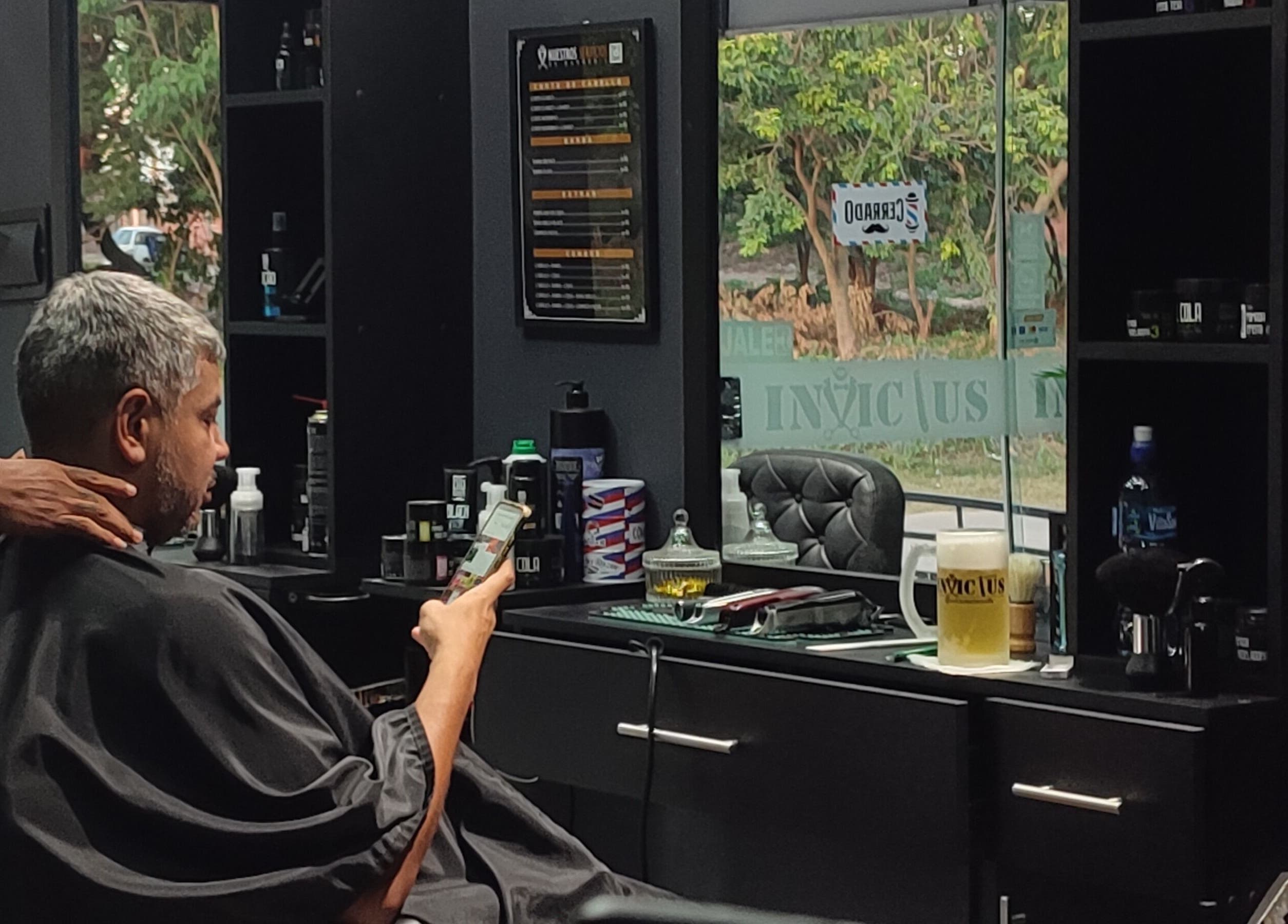 Cliente relajado en Invictus Barbers & Coffee, Santa Cruz de la Sierra, BO, disfrutando de un corte de cabello.