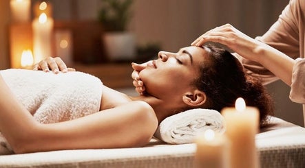 Woman enjoys a calming head massage at Mica Spa Wellness in Vaughan, Ontario, CA with warm candlelight ambiance.