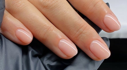 Elegant manicured nails at Melly's Beauty Parlour, Newstead, Queensland, AU, showcasing glossy pink finish.