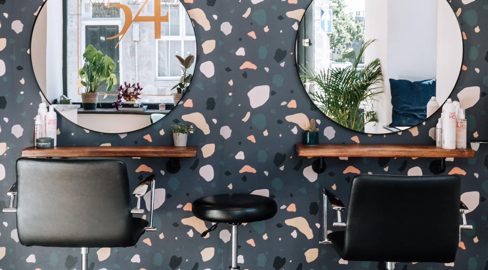 Stylish salon chairs at Studio 54 in Aberdeen, Scotland, GB, featuring modern decor and inviting mirrors.