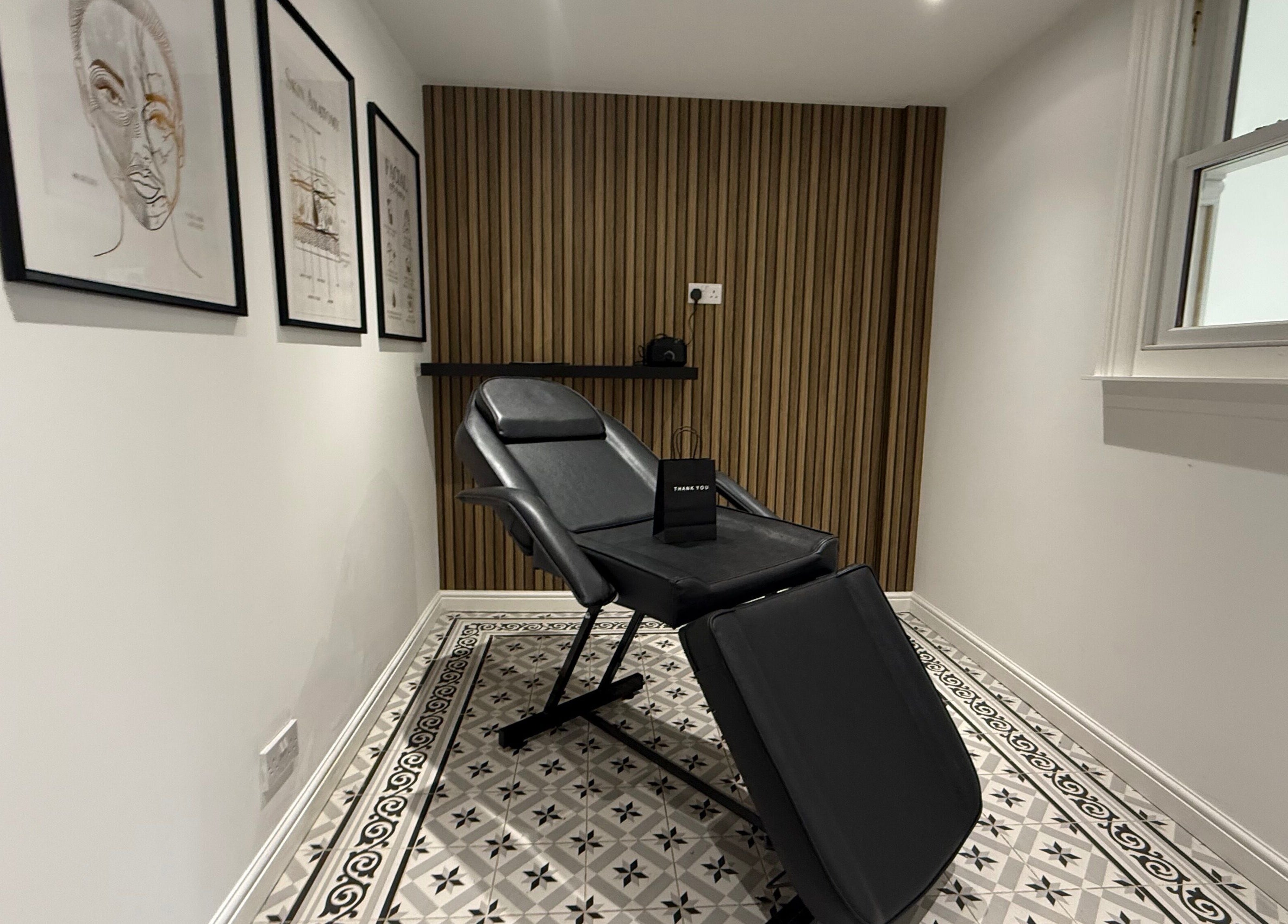 Modern treatment room at Lashmek, Edinburgh, Scotland, GB with sleek decor and comfortable chair.