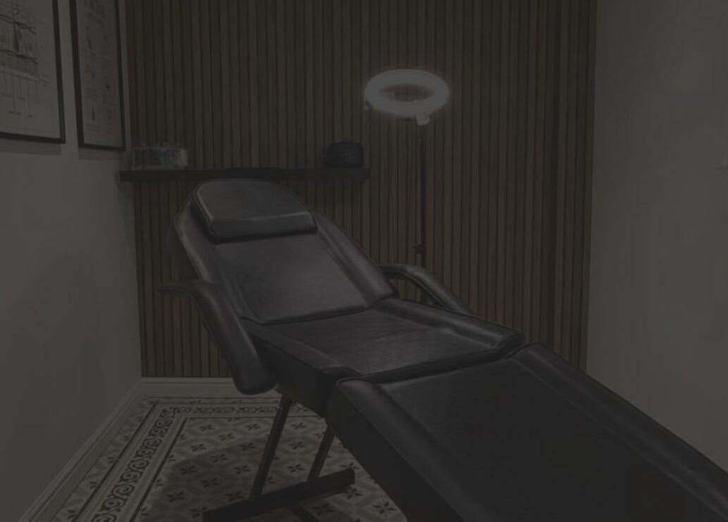 Calm treatment room at Lashmek, Edinburgh, Scotland, GB, featuring a sleek black chair and ambient lighting.