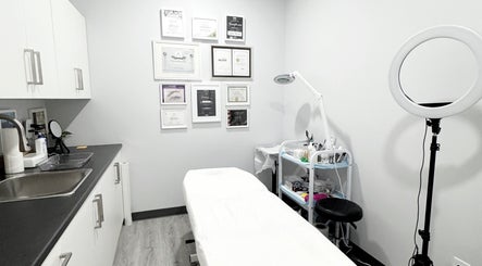 Treatment room at JM Permanent Makeup, Edmonton, Alberta, CA with a bed, certificates, and beauty equipment.