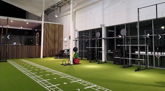 Modern gym equipment on green turf at EMF Performance and Recovery Centre | Nerang, Highland Park, Queensland, AU.