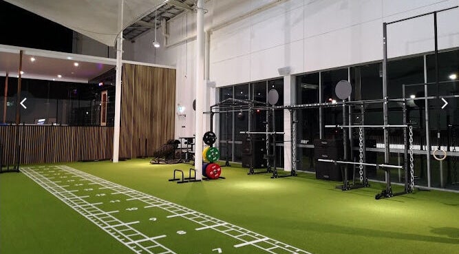 Modern gym equipment on green turf at EMF Performance and Recovery Centre | Nerang, Highland Park, Queensland, AU.