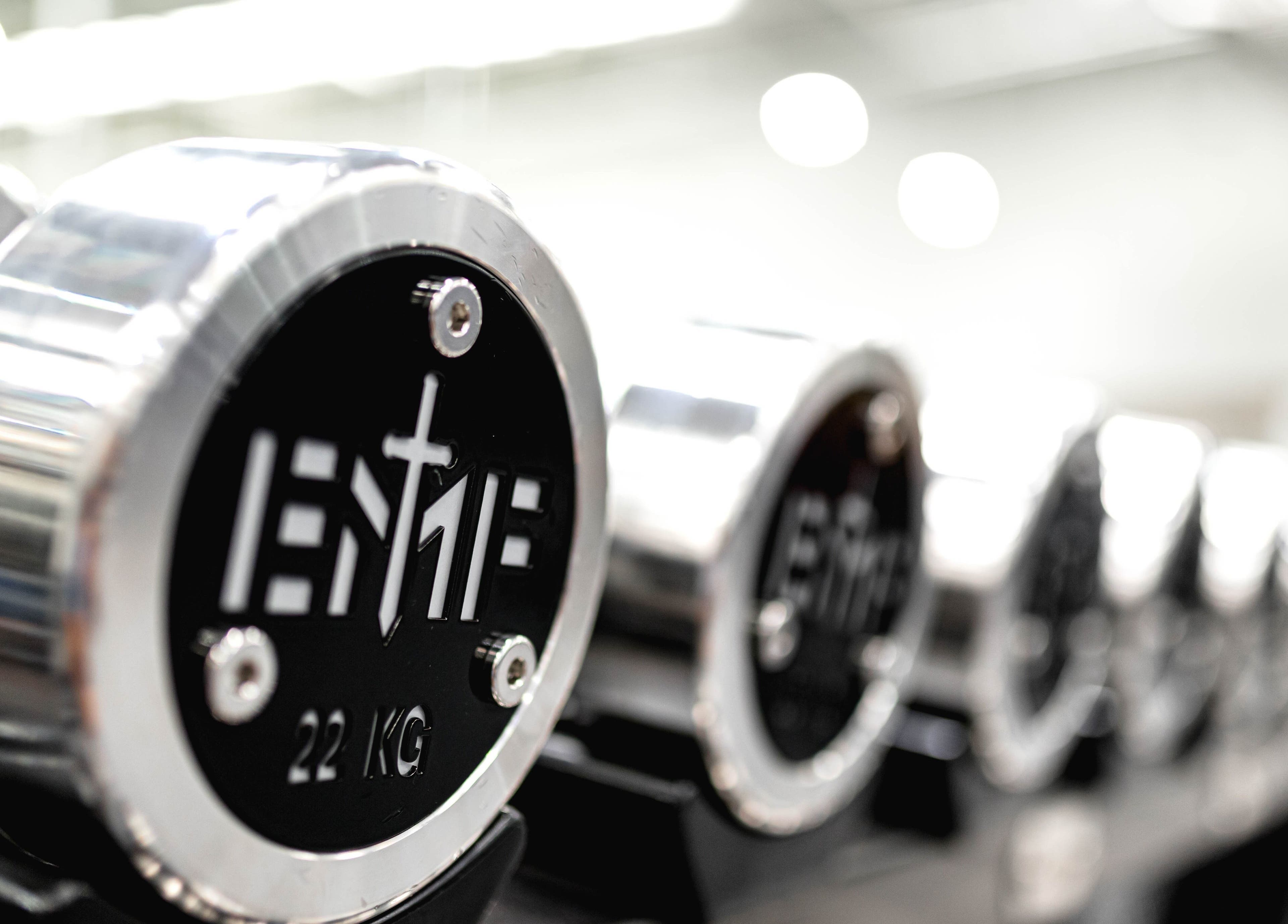 Dumbbells at EMF Performance and Recovery Centre | Nerang, Highland Park, Queensland, AU, shine in gym lighting.