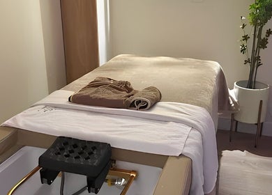 Relaxing spa room at TT Head Spa Long Beach, Long Beach, California, US. Cozy massage bed with towels and plant decor.