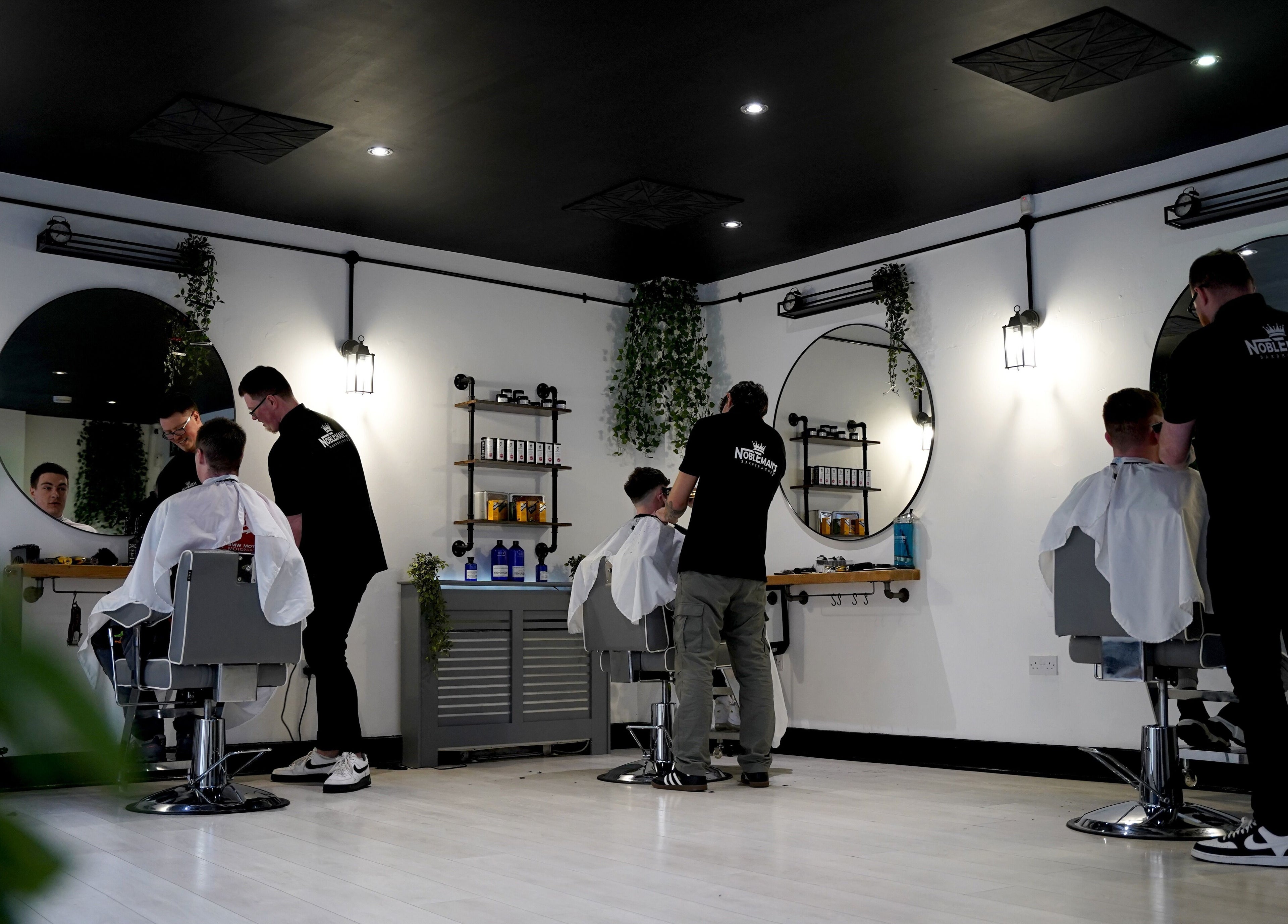 Chic interior of Nobleman's Barbershop Newbridge, Newbridge, County Kildare, IE with clients and barbers.
