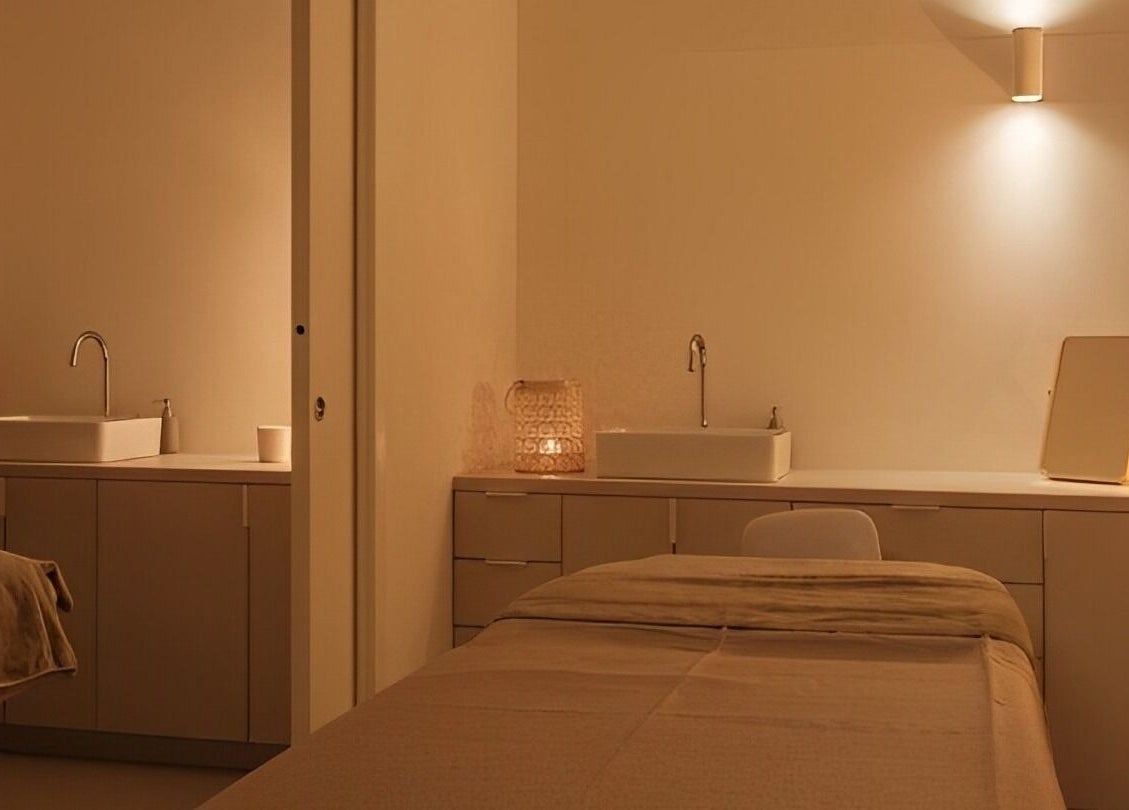 Smirujući prostor Domasi salona za masažu u Zagrebu, HR, s toplim osvjetljenjem i udobnim krevetom.