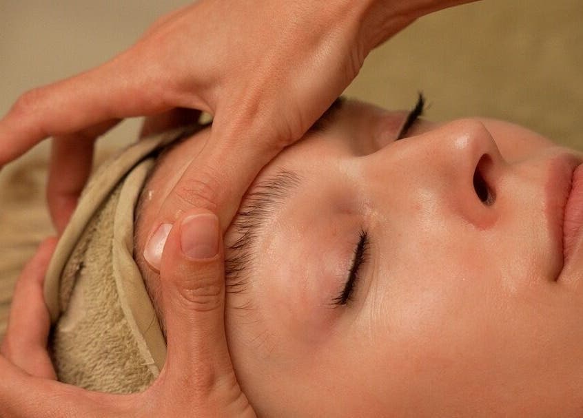 Osoba prima opuštajuću masažu lica u Domasi, Zagreb, HR, uz nježne ruke terapeuta.