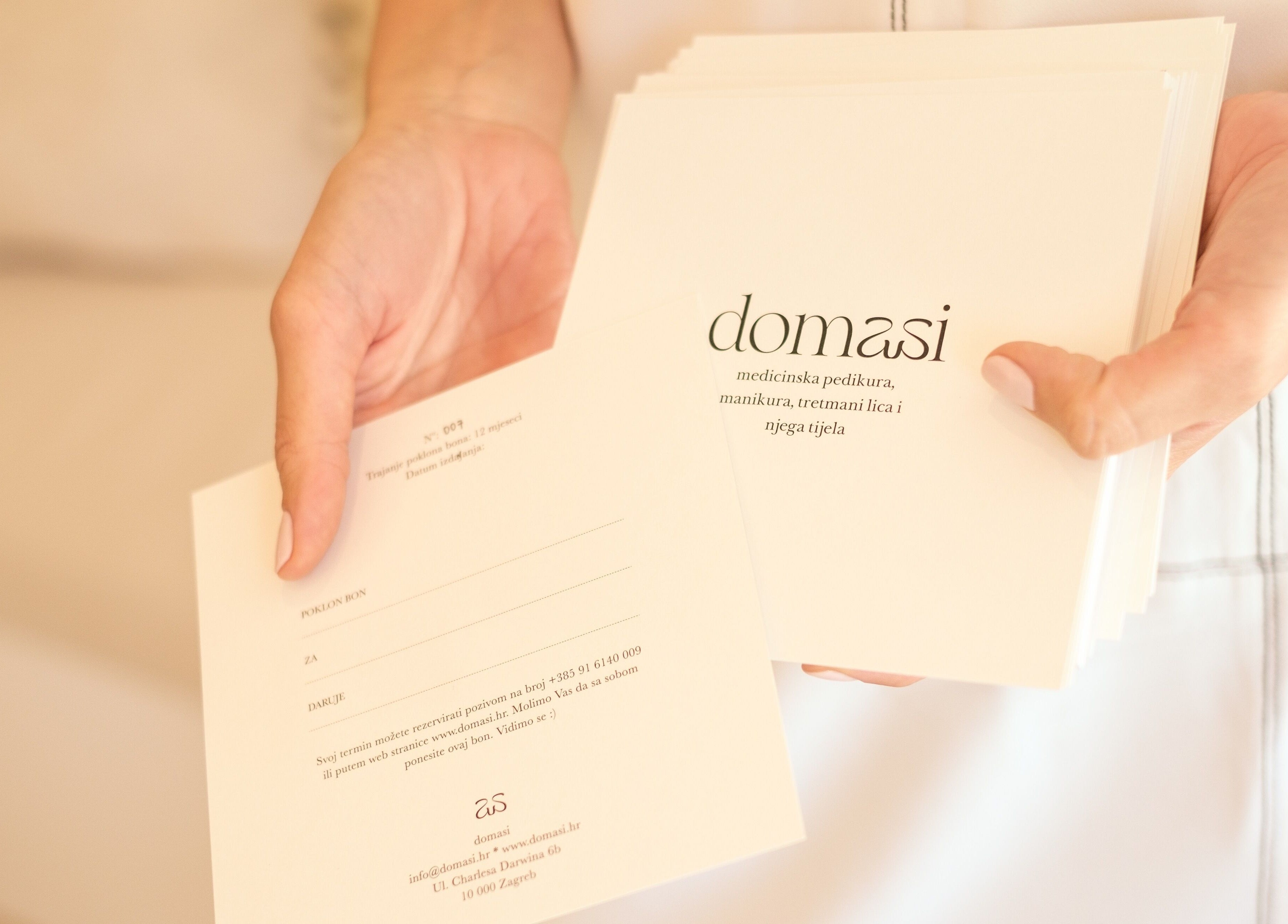 Osoba drži pozivnice iz Domasi salona za uljepšavanje u Zagrebu, HR.