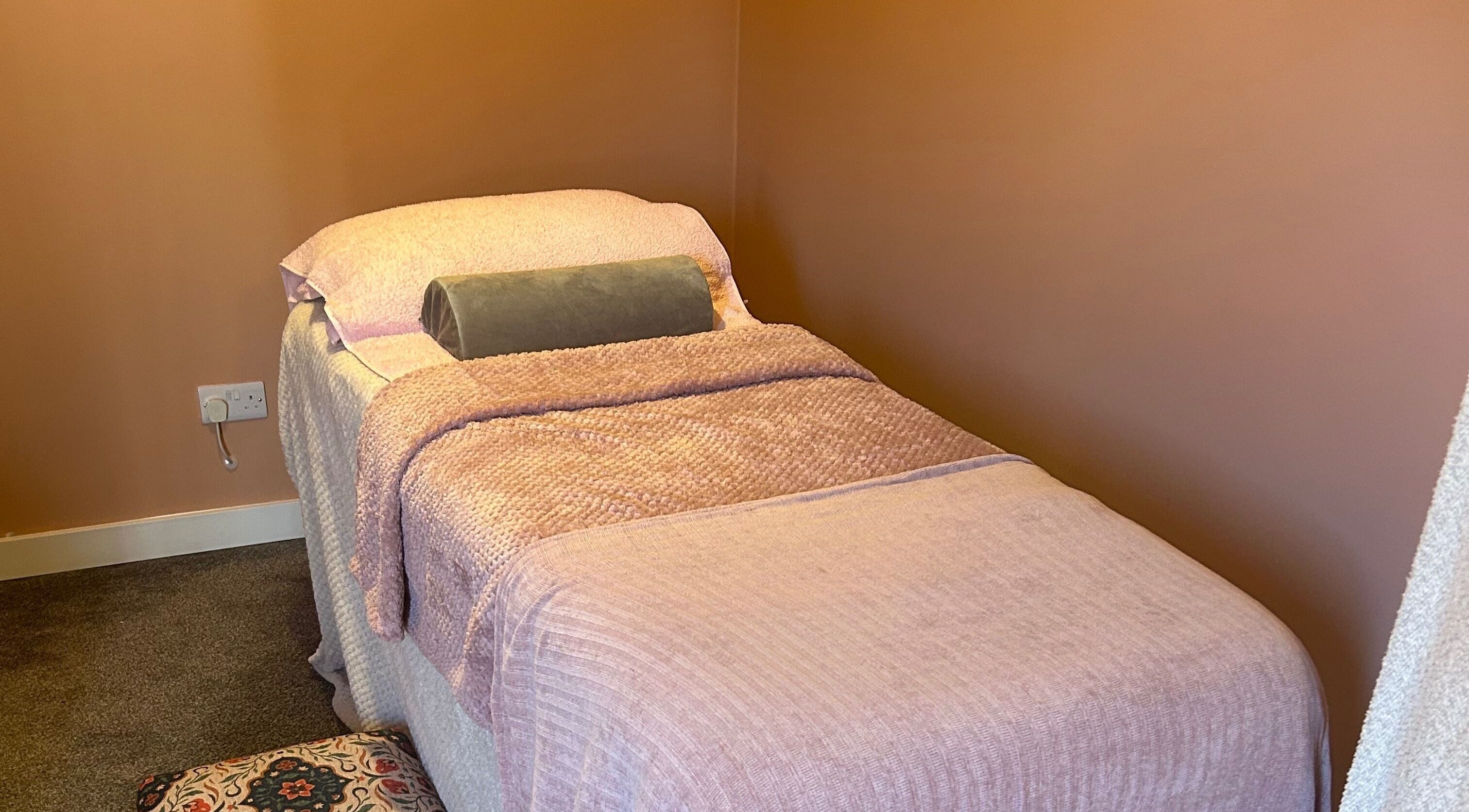 Relaxing massage room at Applewood Wellness, Upton, England, GB with soft lighting and cozy furnishings.