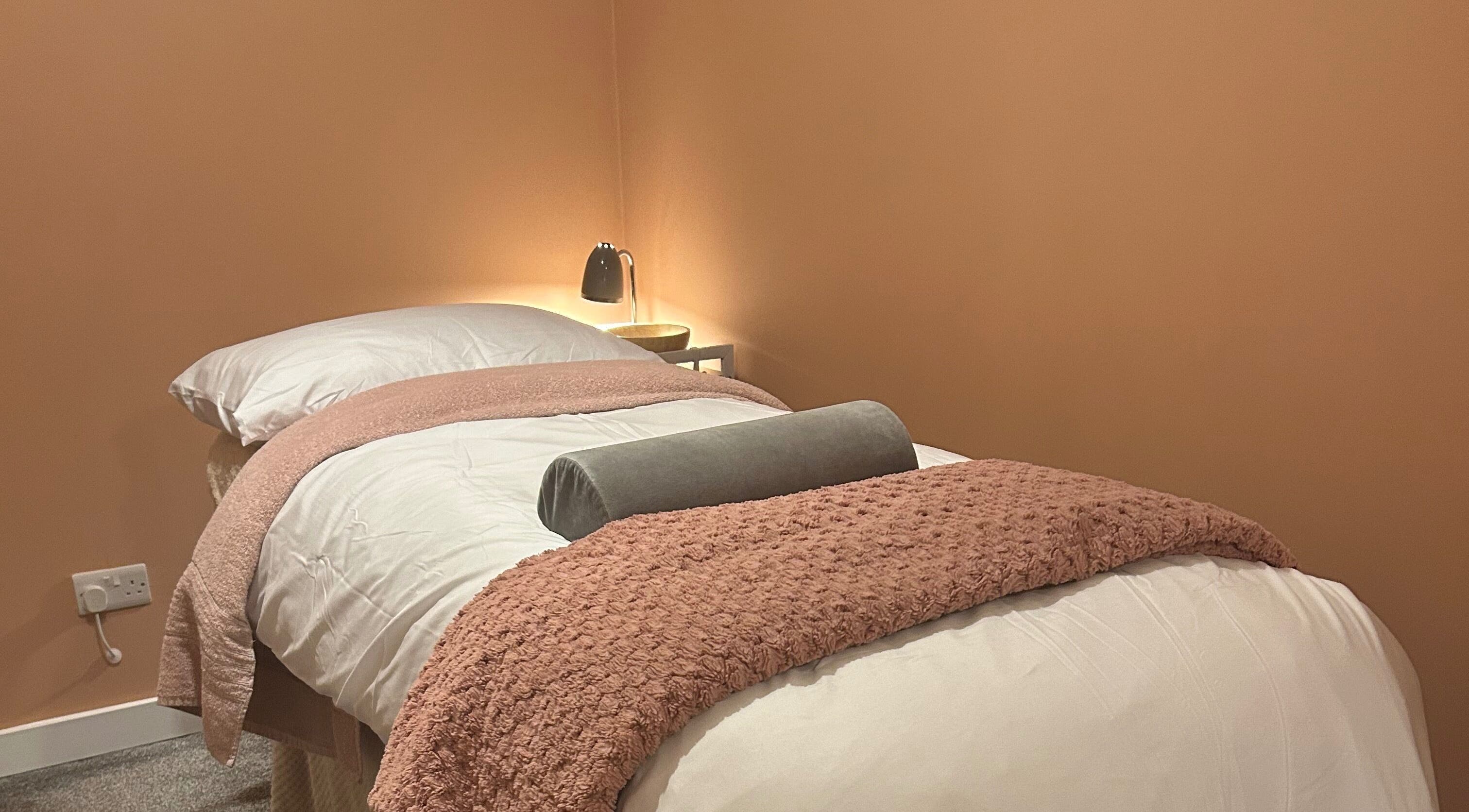 Cozy treatment room at Applewood Wellness in Upton, England, GB with soft lighting and plush bedding.