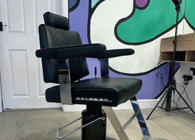 Modern barber chair at Blades Barbers in Hereford, England, GB with vibrant mural background.