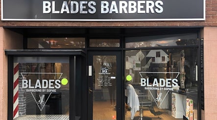 Front view of Blades Barbers shop in Hereford, England, GB, showcasing modern glass storefront.