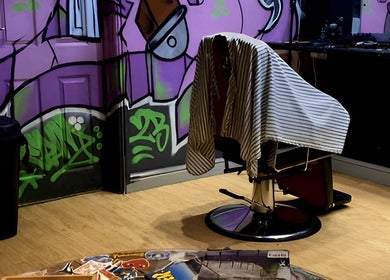 Stylish graffiti decor and barber chair at Blades Barbers, Hereford, England, GB.