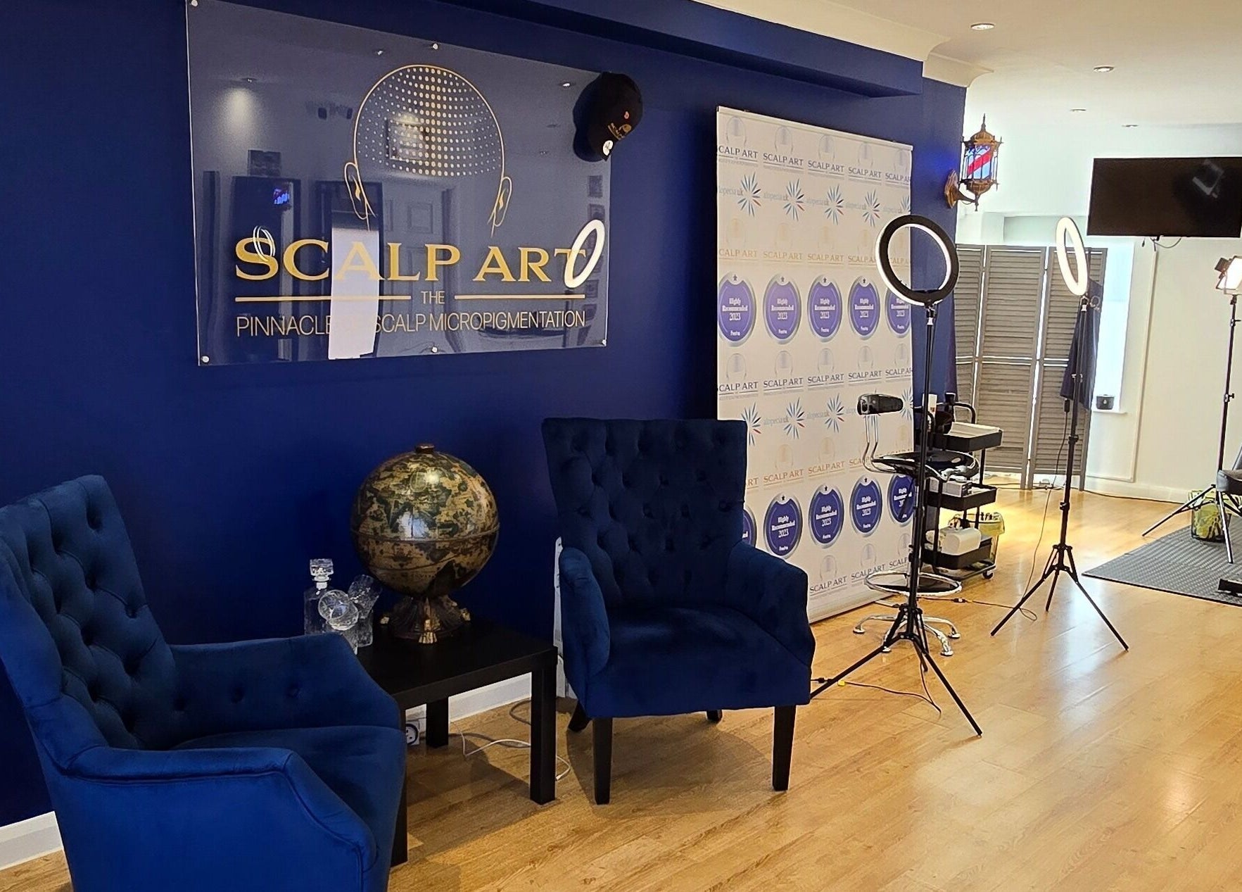 Elegant interior of Scalp Art Clinic in South Woodham Ferrers, England, featuring blue chairs and modern decor.
