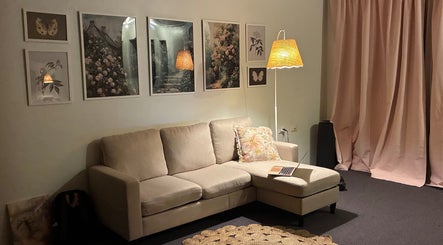 Elegant lounge area at Lashed By Maya, Westmead, New South Wales, AU with art pieces and soft lighting.