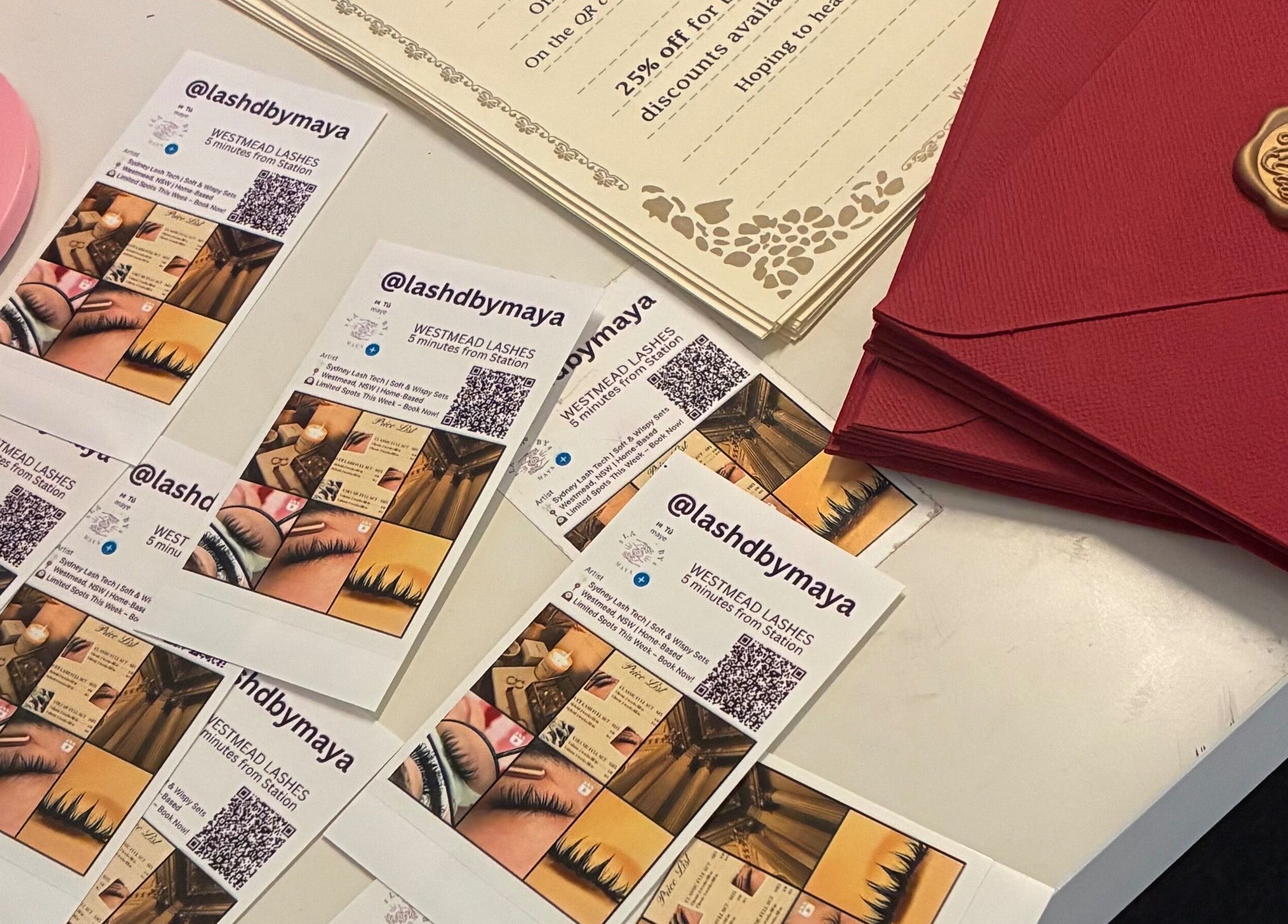Promo cards and red envelopes at Lashed By Maya, Westmead, New South Wales, AU, showcasing lash services.