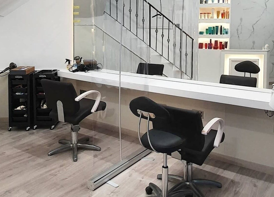 Modern salon setup at Leonards Hair, Tas-Sliema, MT featuring sleek chairs and mirrors.