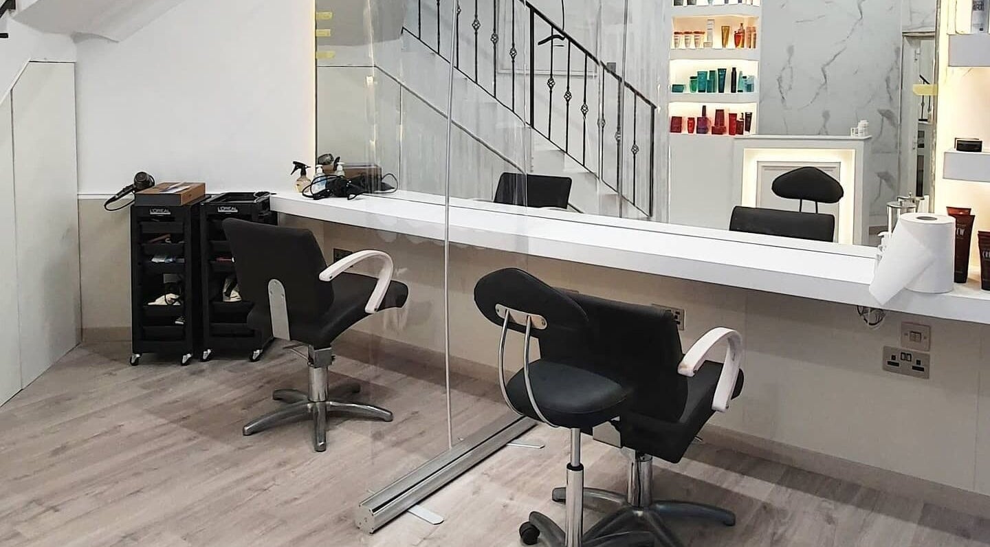 Modern salon setup at Leonards Hair, Tas-Sliema, MT featuring sleek chairs and mirrors.