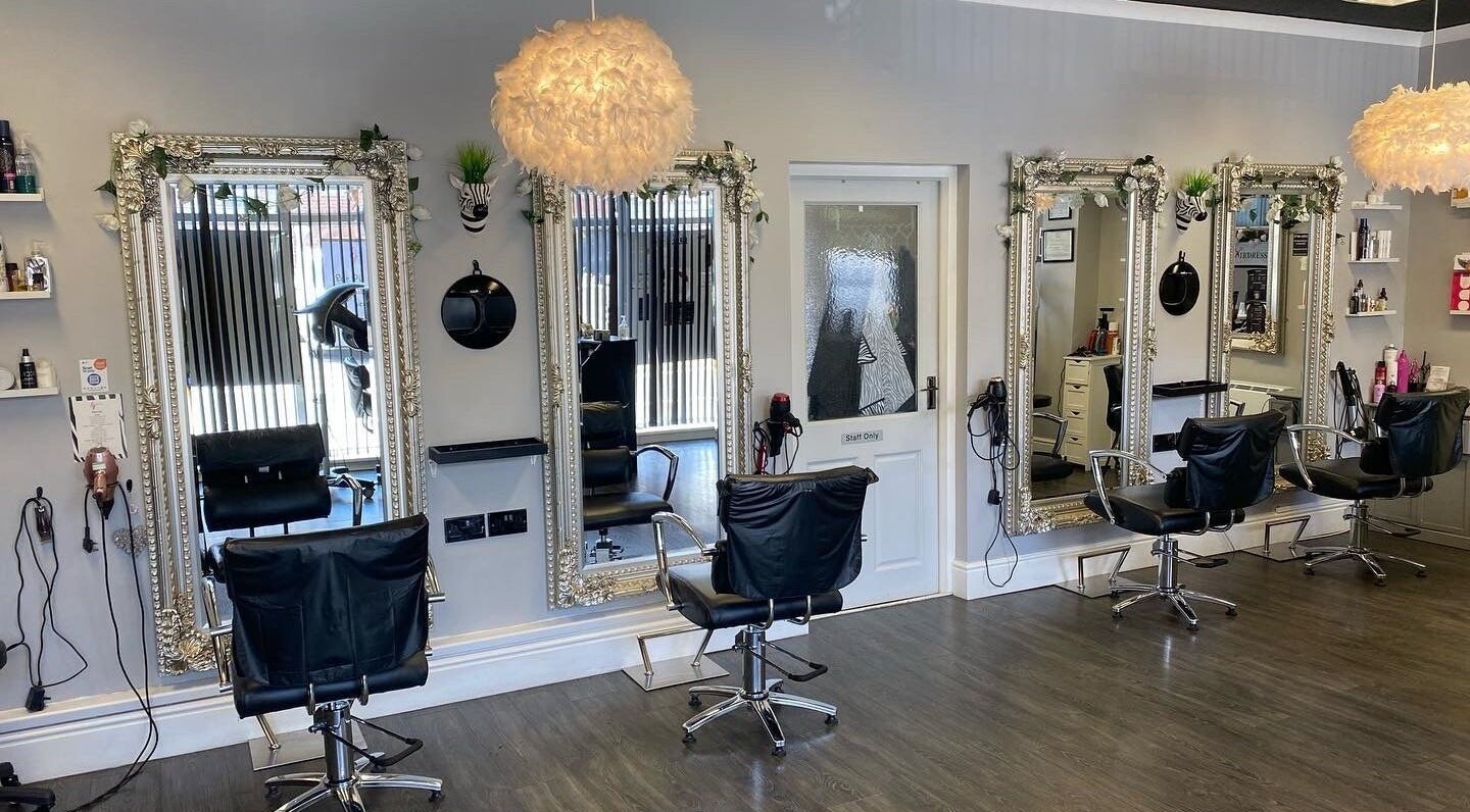 Interior of HJ Hairdressing, Beauty & Aesthetics in Stafford, England, GB showcasing elegant styling stations.