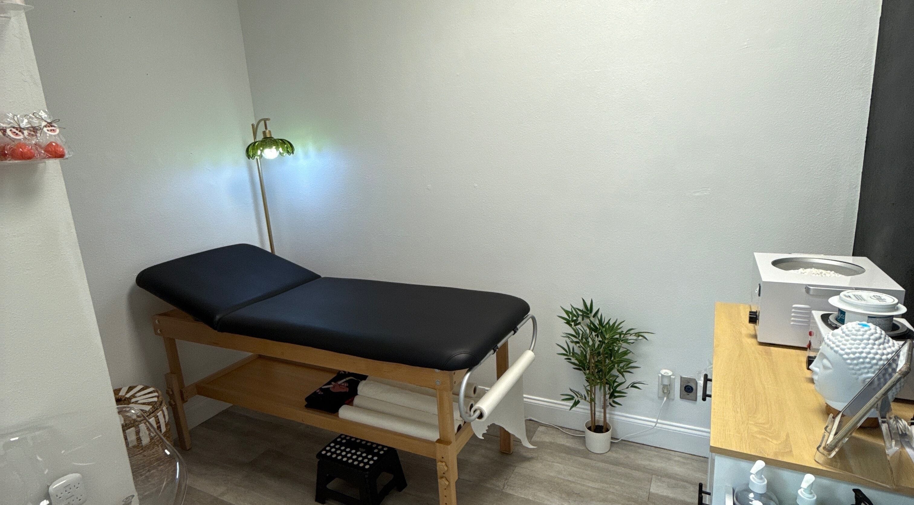 Cozy treatment room at Bella Peach, Sarasota, Florida, US, featuring a comfortable massage table and ambient lighting.