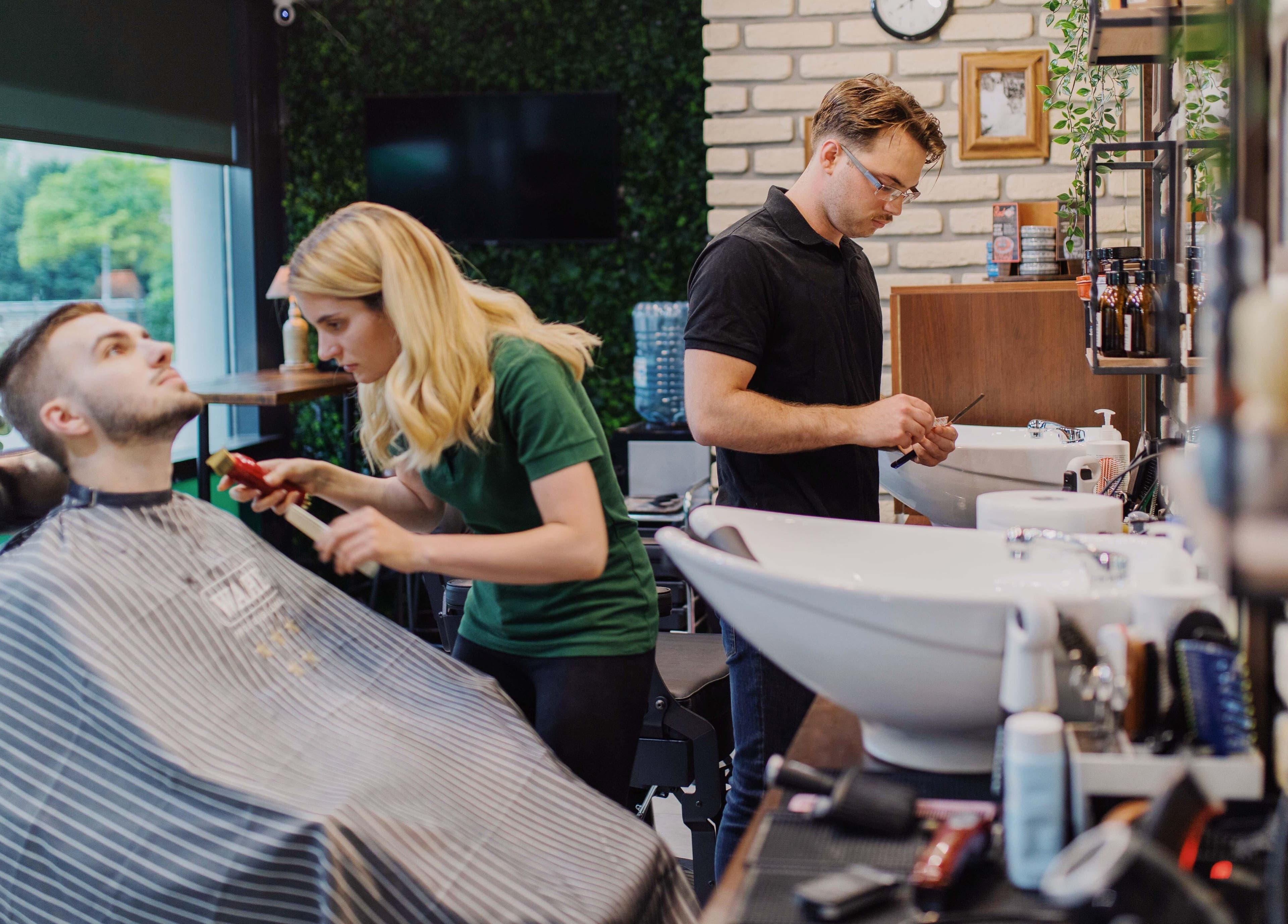 Frizerka u Nomad Barbershop Zagreb Tower (ex Oliver's) šiša klijenta. Lokacija: Zagreb, Grad Zagreb, HR.