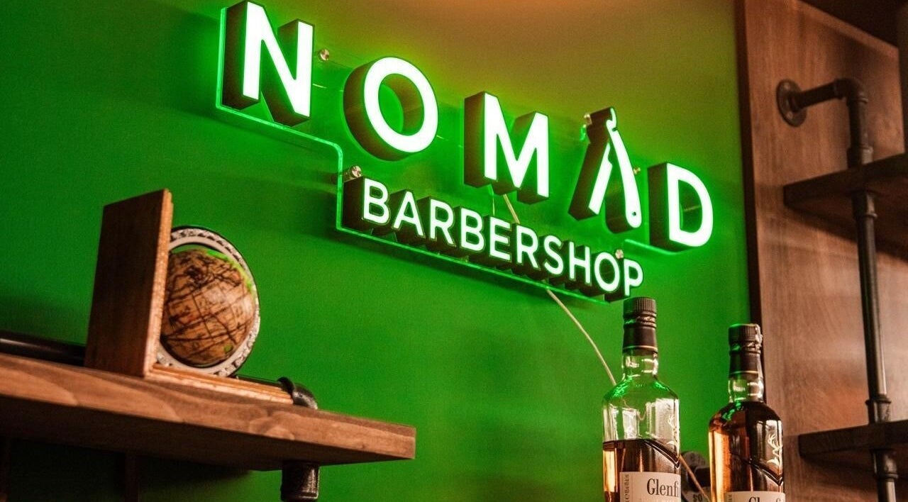Svjetleći znak Nomad Barbershop Vrbani, Zagreb, Grad Zagreb, HR, s bocom viskija u prvom planu.