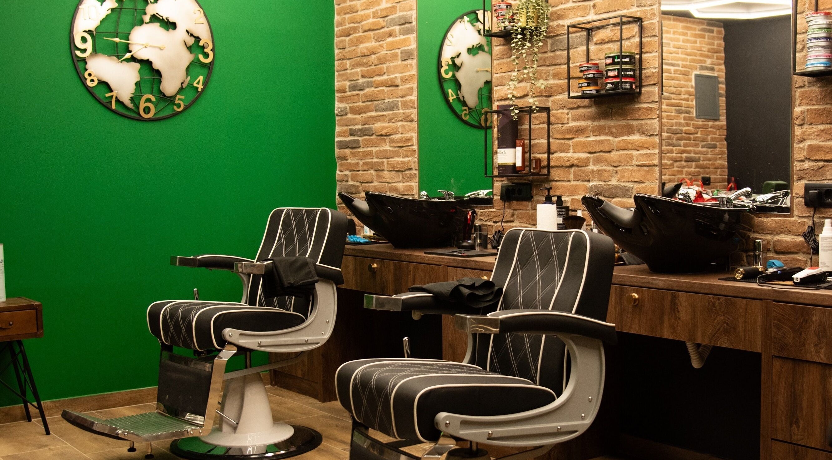 Moderna brijačnica Nomad Barbershop Lanište u Zagrebu s elegantnim stolicama i zidom cigle.