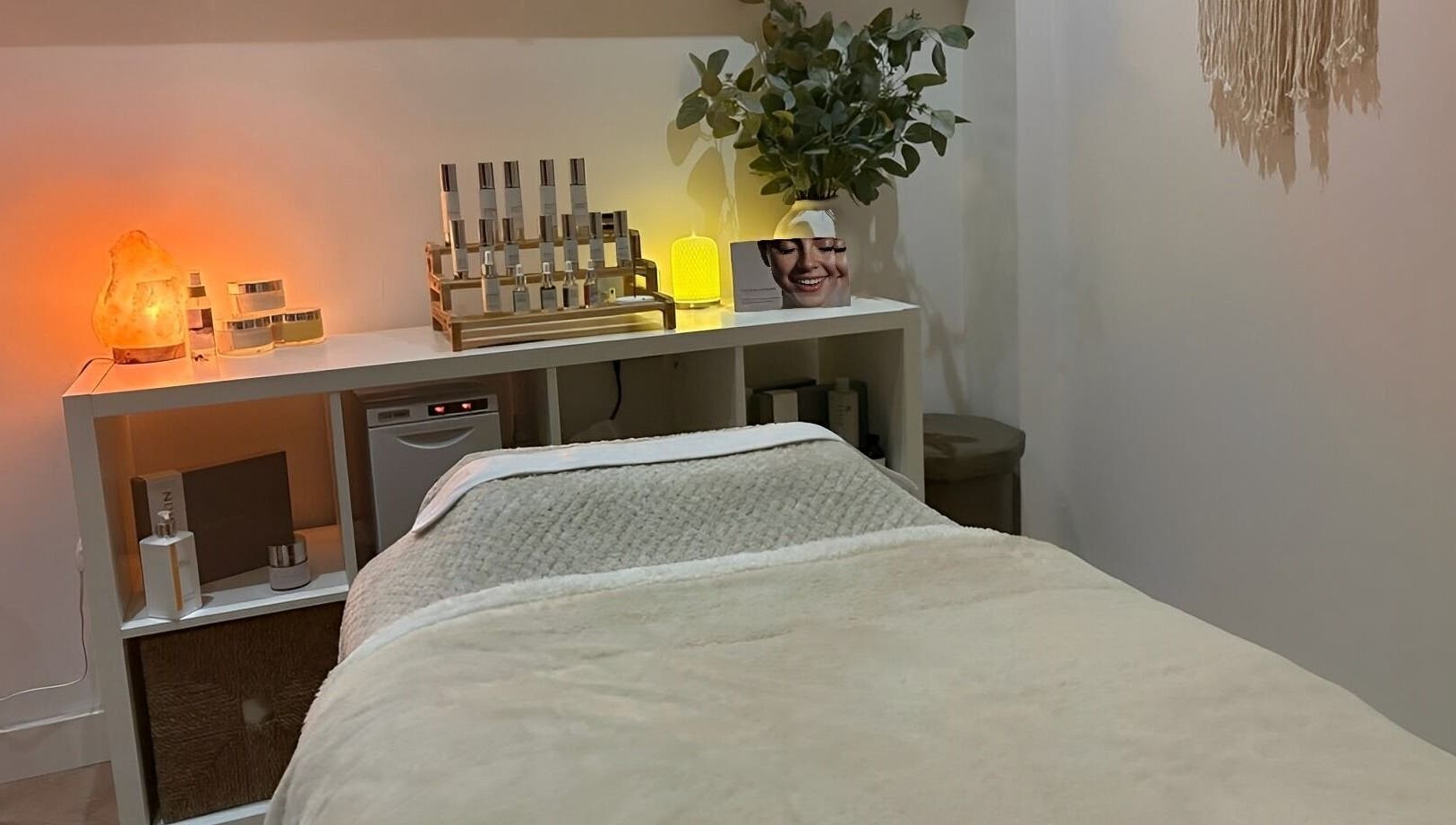 Cozy spa treatment room at Harringtons Devizes, GB with warm lighting and skincare products.