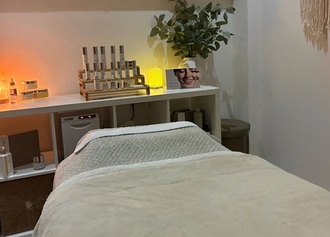 Cozy spa treatment room at Harringtons Devizes, GB with warm lighting and skincare products.