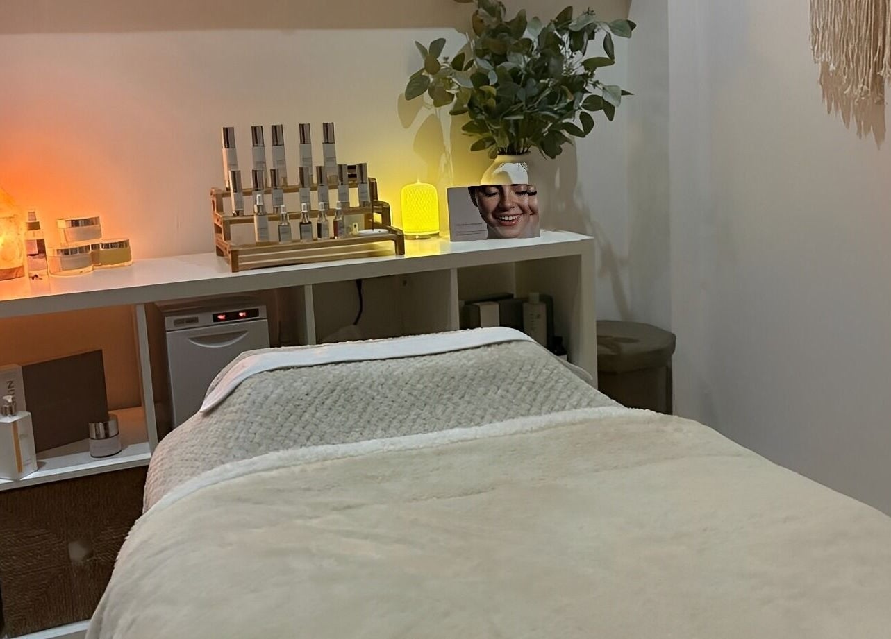 Cozy spa treatment room at Harringtons Devizes, GB with warm lighting and skincare products.